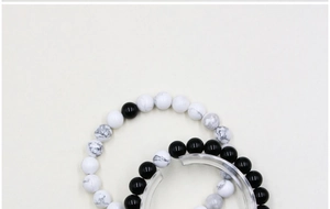 Close-up of 8mm black onyx and white turquoise beads on elastic couple bracelets