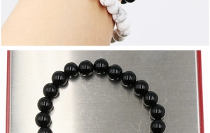 Close-up of 8mm white turquoise and black agate beaded bracelets set in a metal tray
