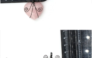 Detail view of handmade rose quartz heart pendant with wire wrap and size measurement