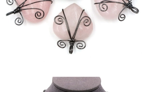 Detail view of heart-shaped pink crystal pendants with handmade black wire wrapping