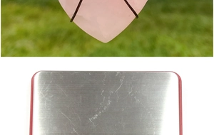Macro detail of heart rose quartz pendant wrapped in black wire with metal ring top