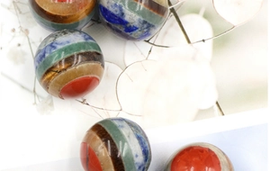Detailed macro view of 20mm round chakra ball made from layered multi-color natural gemstones