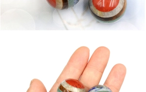 Macro view of a 20mm chakra crystal energy ball showing vibrant layered gemstone colors