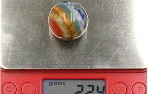 Macro detail of a 20mm 7 chakra gemstone ball weighing 22.4g on a scale