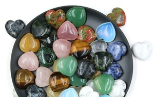 Gros plan de pierres de cristal polies en forme de cœur, quartz rose et œil de tigre