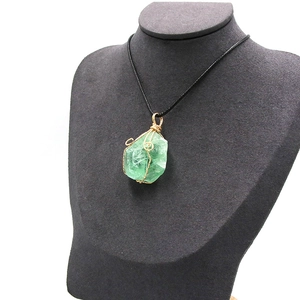 Collar artesanal con colgante de cristal verde en bruto envuelto en hilo dorado