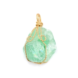 Colgante de cristal verde natural envuelto en alambre dorado hecho a mano en fondo blanco