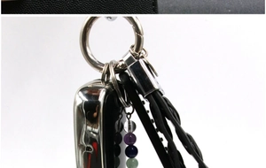 Detail of amethyst crystal keychain with colorful gemstone beads and woven black cord