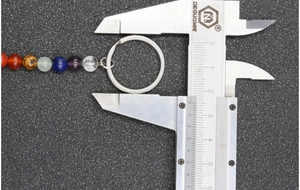 Measuring seven chakra beaded keychain ring diameter with a precise vernier caliper