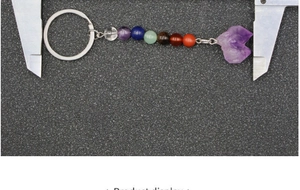 Macro detail of natural chakra stones keychain with measuring caliper for size reference