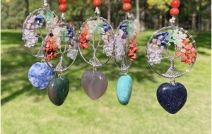 Detail of tree of life heart pendants featuring handmade wire wrap and natural gemstones