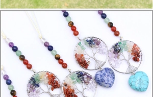 Macro detail of Tree of Life chakra pendants with colorful stones and heart-shaped crystals