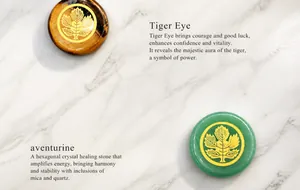 Tiger eye and green aventurine stone pendants with golden leaf pattern on white background