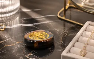 Macro view of flat round tiger eye stone charm with gold pattern on polished surface