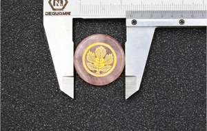 Detalle de cuarzo rosa de 30mm con emblema de árbol dorado medido con un calibre