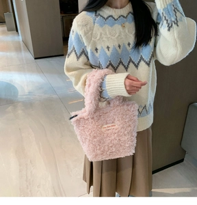 Pink plush faux fur handbag styled with a geometric knit sweater and pleated midi skirt