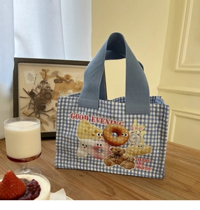 Dettaglio della borsa da pranzo in tela a quadretti blu con orsetto e ciambelle