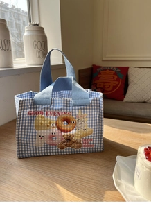 Dettaglio della borsa da pranzo a quadretti blu con orsetto e ciambella su legno