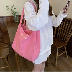 Pink canvas tote bag with maaaaas print shown in a cozy cafe setting for daily use