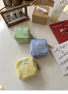 Tre borse a quadretti per assorbenti con etichetta Lime su scrivania in stile sobrio