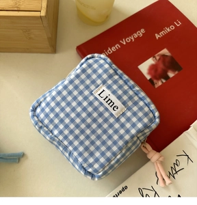 Dettaglio della pochette a quadretti blu con etichetta Lime e tirazip rosa intrecciato