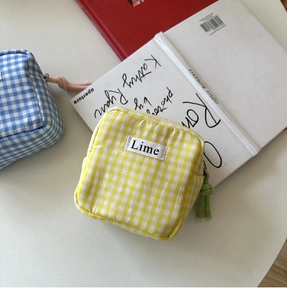 Dettaglio di mini borse in tela a quadretti gialli e blu con chiusure a zip in corda colorata
