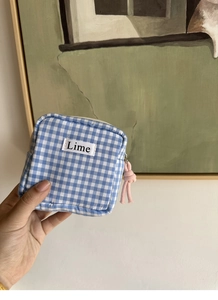 Dettaglio della borsa a quadretti blu con etichetta Lime e cerniera a nodo rosa
