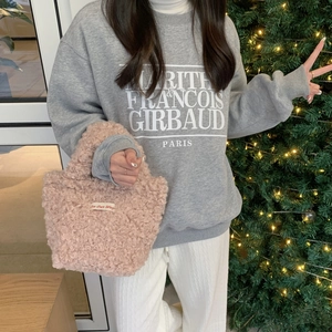 Chic pink teddy fur tote bag styled with gray sweatshirt and festive holiday background