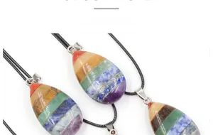Detailed view of layered chakra stone teardrop pendants with black wax cord necklaces