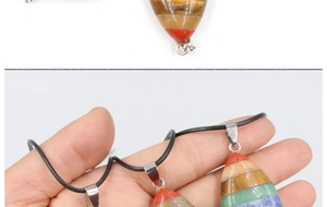 Macro view of colorful 7 chakra stone pendant with silver clasp and black cord