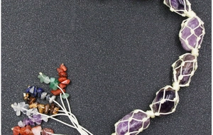 Macro detail of hand-woven purple amethyst stone hanger with chakra crystal tassels