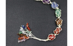 Detail of seven chakra gemstones in handmade macrame woven netting for yoga decor