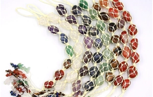 Detail of assorted hand-woven natural crystal stone pendants with decorative tassels