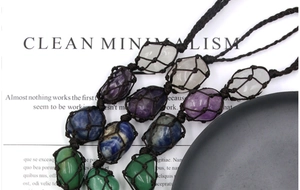 Detail of handcrafted woven net necklaces with natural raw crystals in various colors
