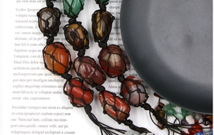 Macro detail of natural chakra stones in hand-woven black net cord with zen background