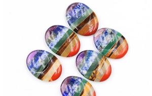 Dettaglio delle pietre ovali dei chakra con diverse texture minerali naturali e colori
