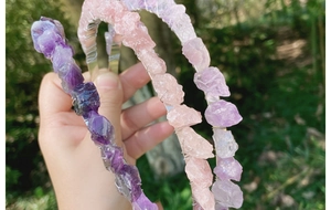 Detail of handmade bohemian crown headband featuring raw amethyst and rose quartz stones