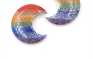 Gros plan du croissant de lune en cristal poli avec pierres de chakra stratifiées