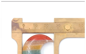 Mesure d'un cristal naturel en forme de lune colorée montrant une largeur de 30mm au calipper