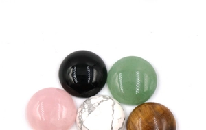 Dettaglio di cinque pietre cabochon rotonde da 20 mm lucidate in vari minerali naturali