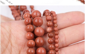 Macro detail of sparkling golden sand stone beads in multiple sizes for DIY jewelry making