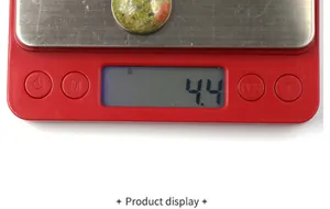 Vista dettagliata di un cabochon in pietra unakite da 4,4g su una bilancia digitale rossa
