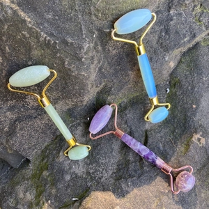 Rulli facciali in quarzo rosa, opale e ametista naturali su una superficie di roccia