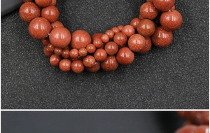Macro shot of orange-brown goldstone beads showing metallic glitter for jewelry making