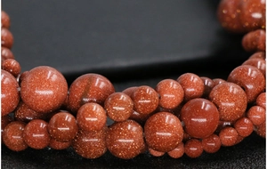 Macro view of glittering brown goldstone beads in various sizes for DIY jewelry