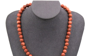 Macro detail of round reddish-brown Goldstone beads with sparkling finish on a necklace