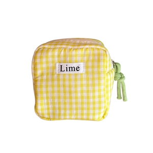 Pochette per assorbenti in tela a quadretti gialli con etichetta Lime e zip verde