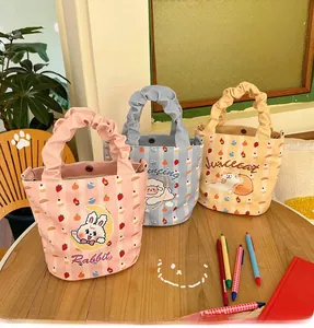 Close-up of cute Japanese style canvas bucket bags with ruffle handles and cat graphics