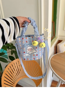 Detail of light blue striped canvas bucket bag with cartoon sheep and ruffled handle