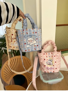 Detailed close-up of colorful cartoon printed canvas bags with pleated handles and straps